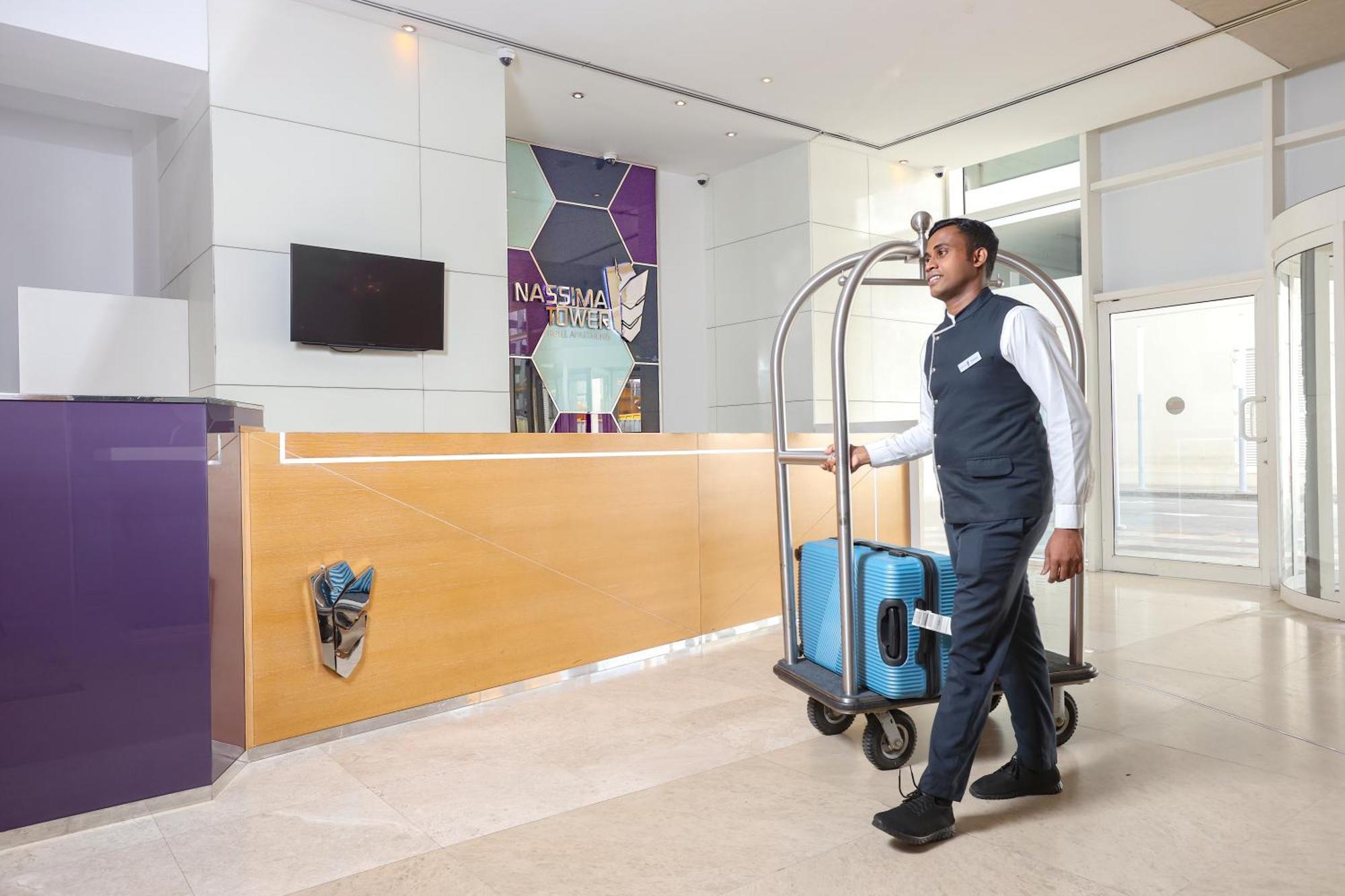 Nassima Tower Hotel apartamentos Dubái Exterior foto A bellboy pushing a luggage cart